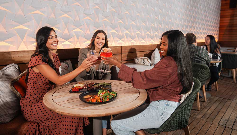 women at Merchant & Trade table with drinks