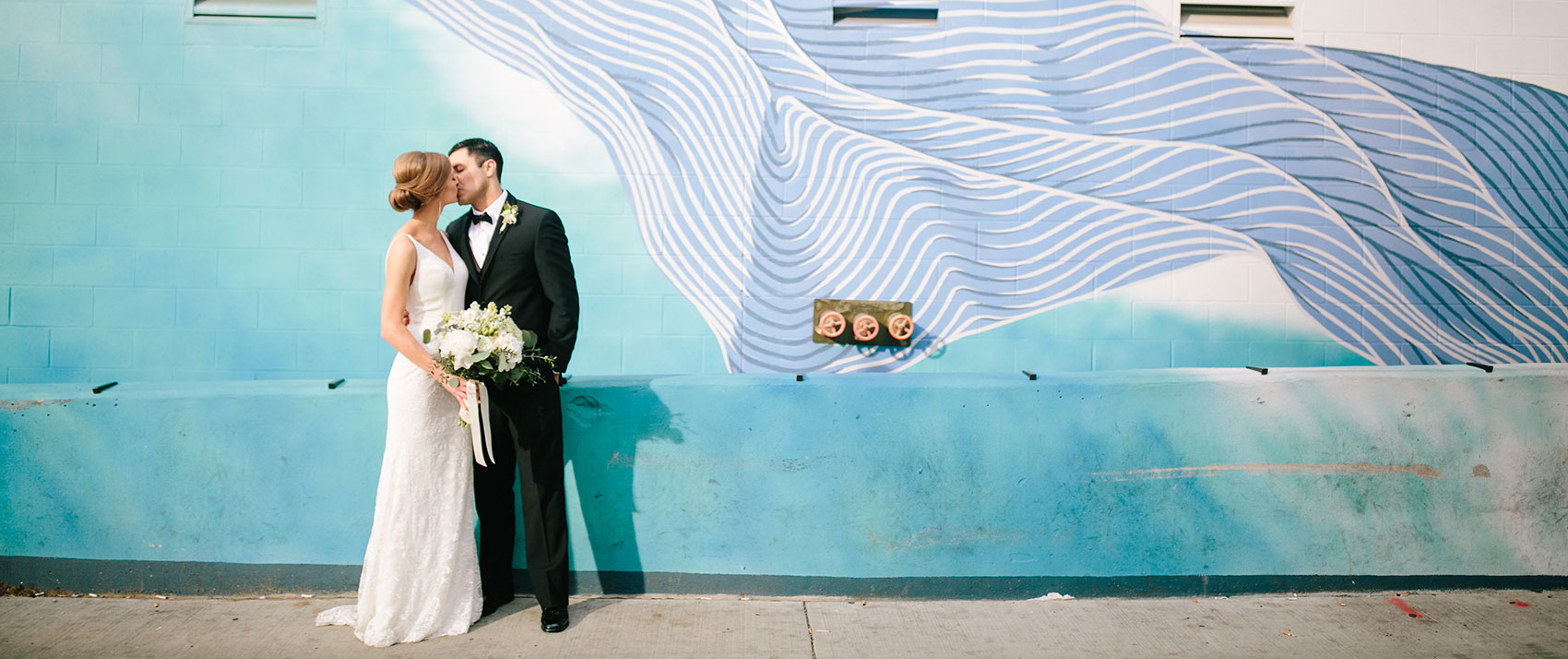 Newlyweds in front of blue wall